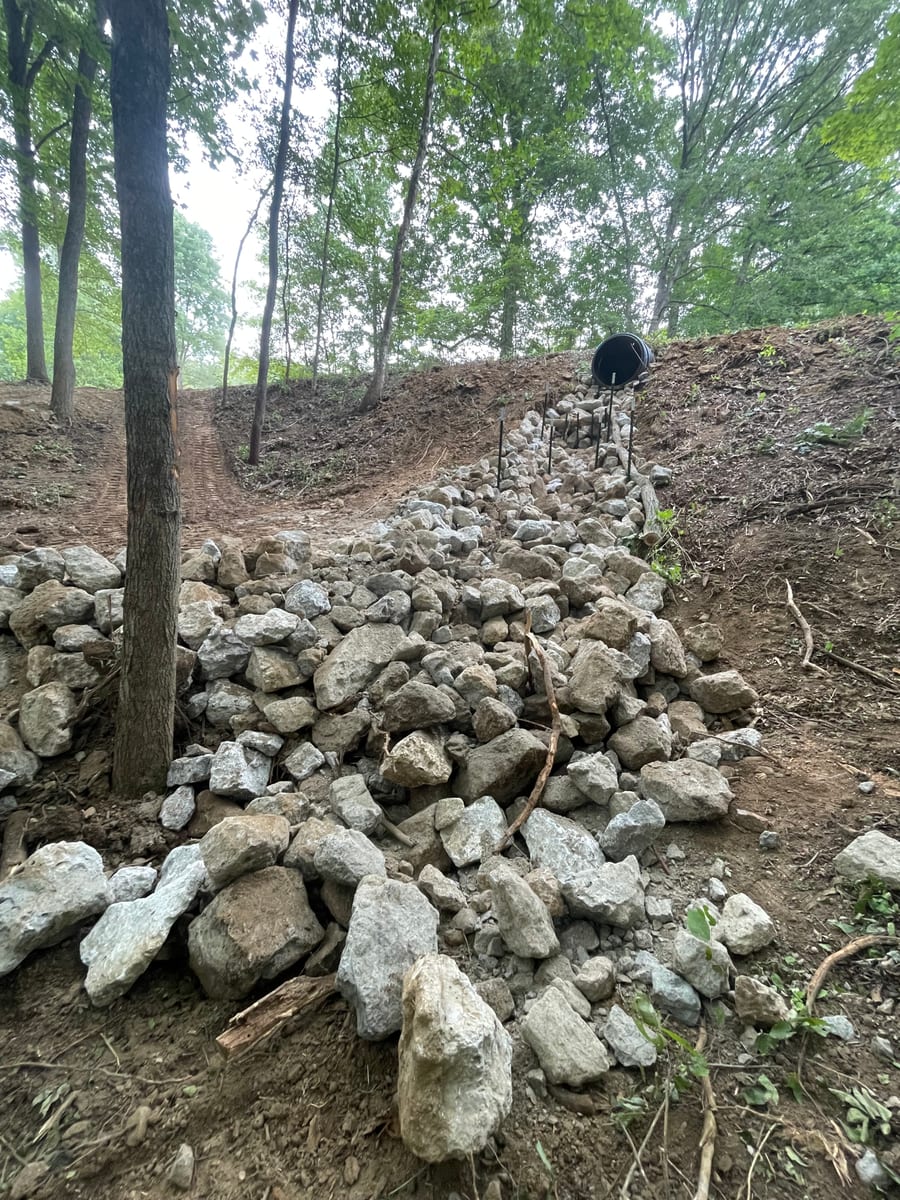 Boulder retaining wall on wooded hillside
